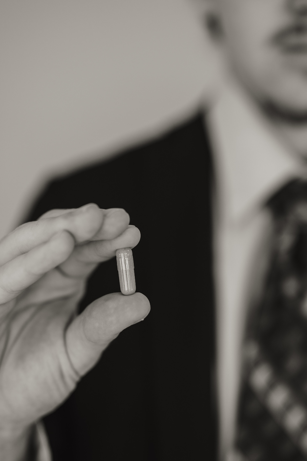 A single Och Wellness capsule held between two fingers